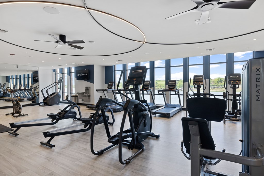 A gym with a variety of equipment including treadmills, stationary bikes, and weight machines.