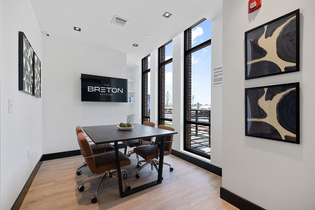 A conference room with a table and chairs and a sign that says "BRETON".