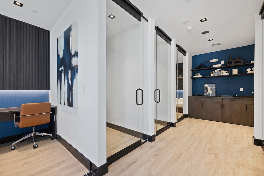 A room with a blue couch and a painting on the wall.