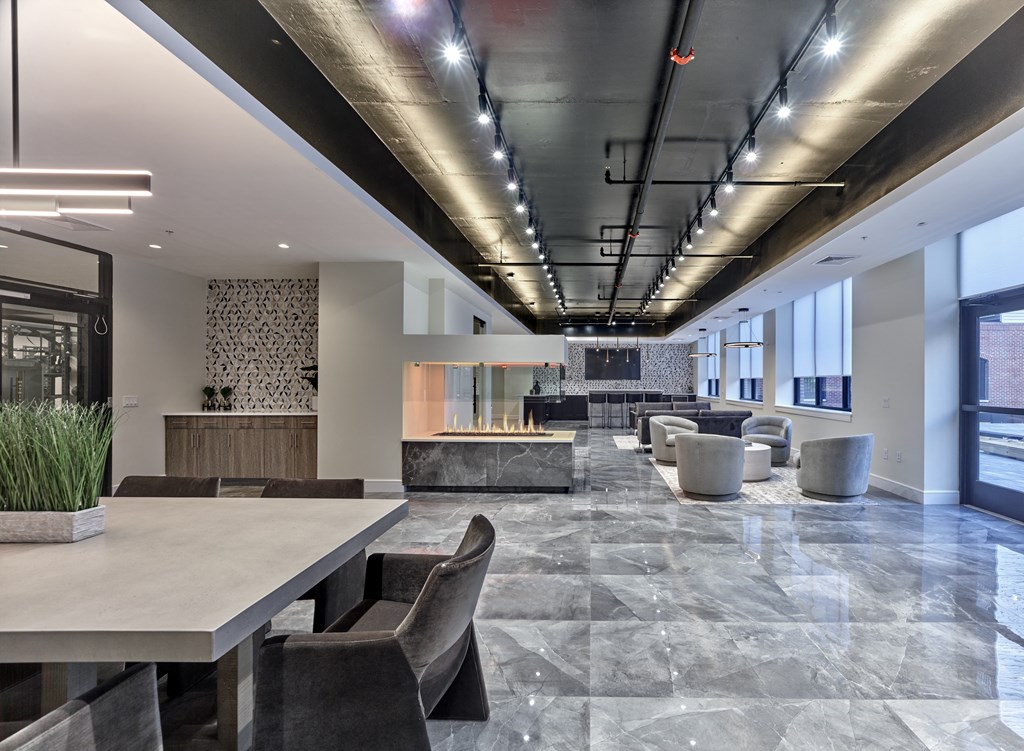 A modern dining area with a long table and chairs.