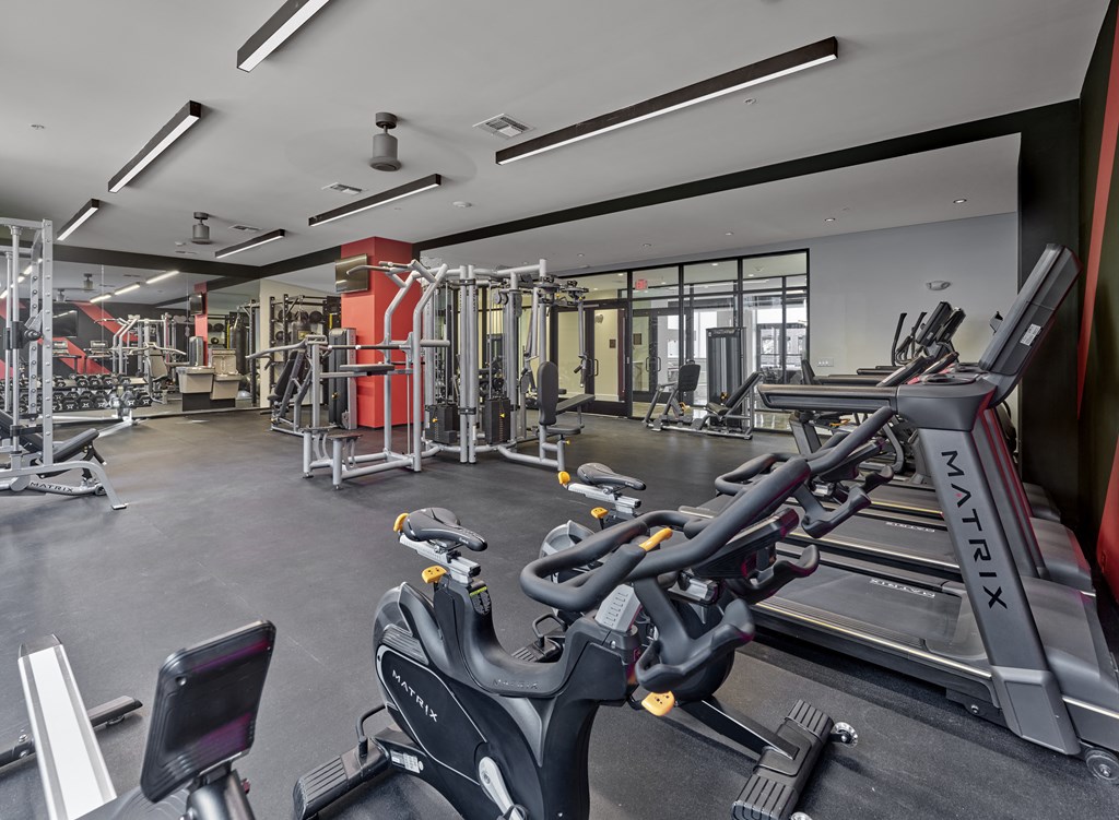 a gym with treadmills and other exercise equipment in a building with glass doors