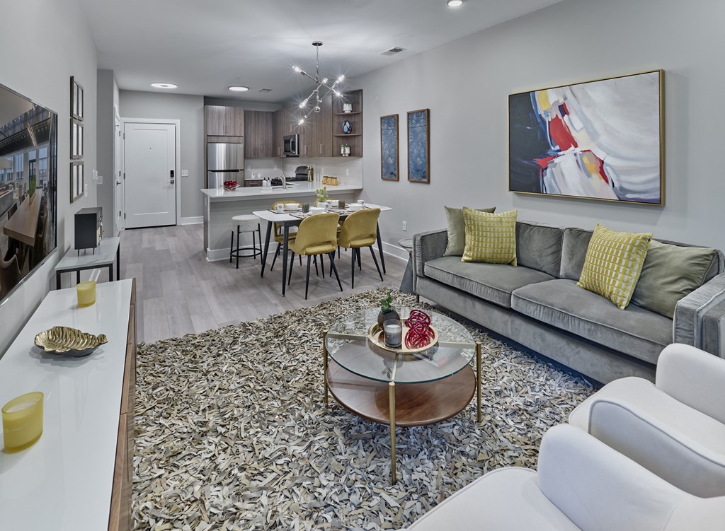 a living room and kitchen with a couch and a table