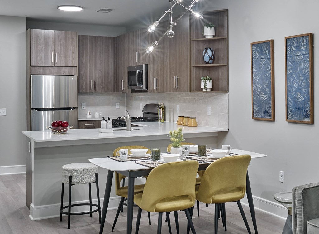 A modern kitchen with a dining table set for two.