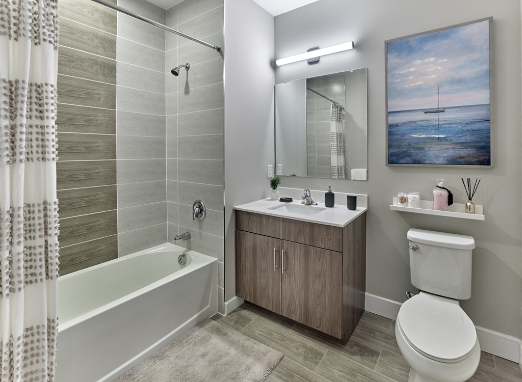 a bathroom with a toilet sink and shower and a mirror