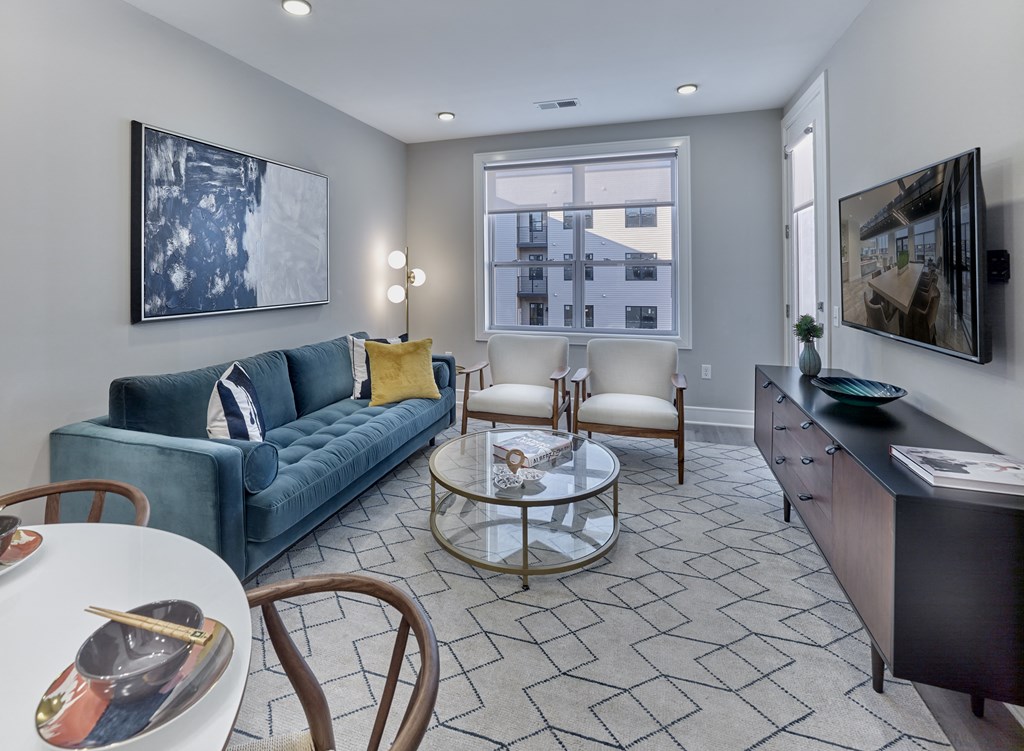a living room with a blue couch and a glass coffee table