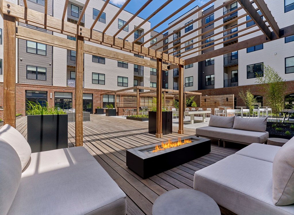 A patio with a fire pit and seating area.