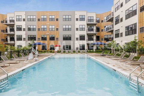 A swimming pool in front of apartment buildings.