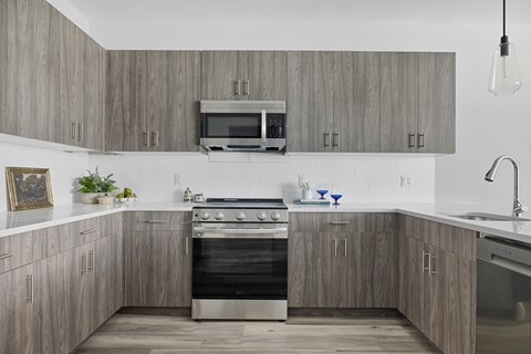 A modern kitchen with a stove top oven and microwave above it.