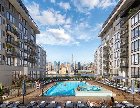 A large swimming pool with lounge chairs and people relaxing on a sunny day.