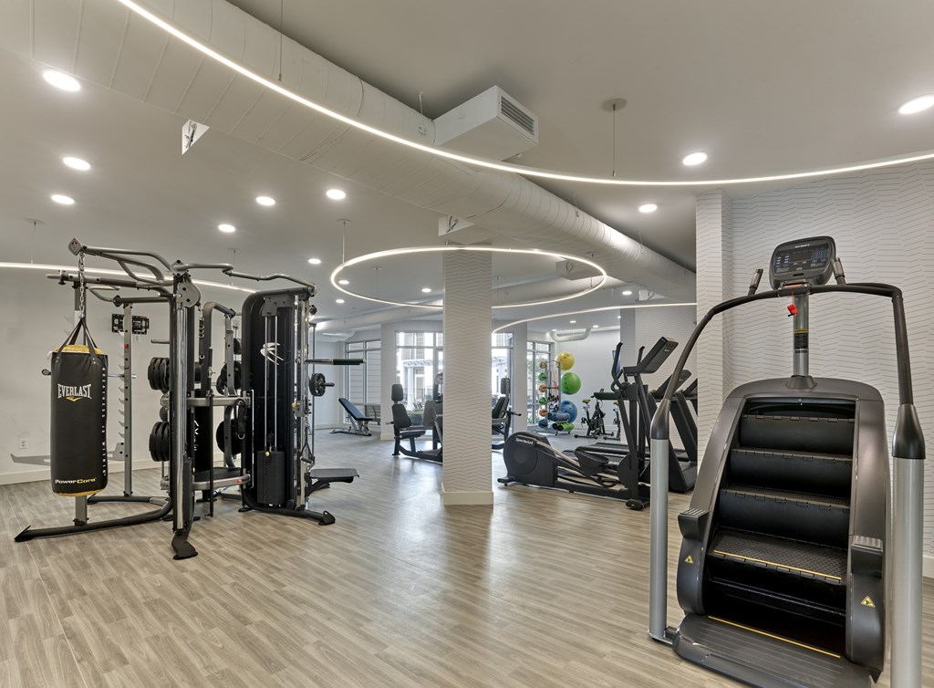 a gym with treadmills and other exercise equipment in a building with white walls