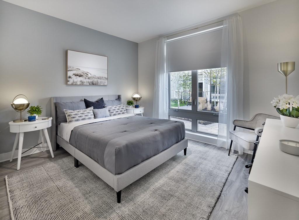 a bedroom with a bed and a desk and a window