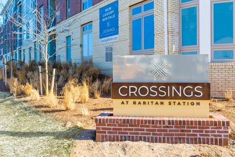 the crossing at raintree station sign in front of a building