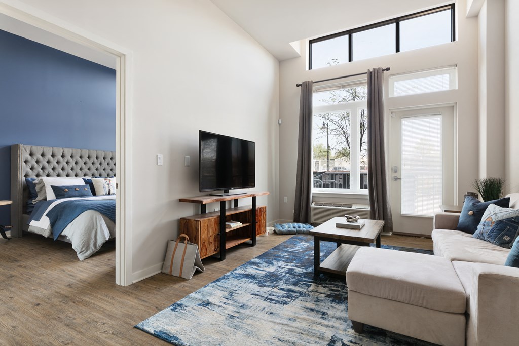 a living room with a couch and a tv and a bed