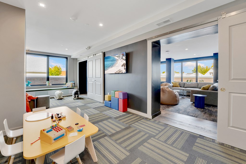 a living room with a desk and a sliding glass door