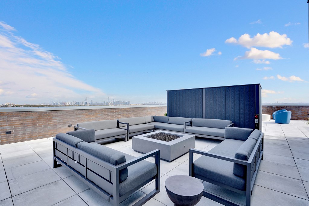 a patio with couches and a fire pit on a roof