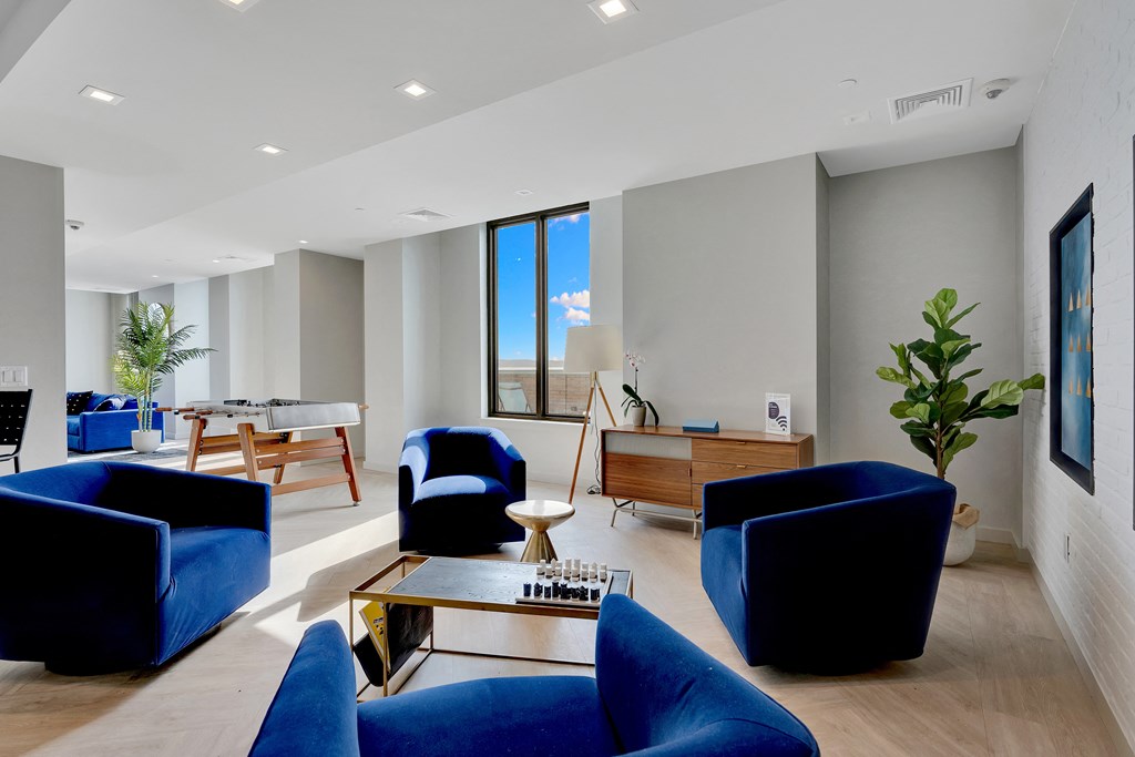 a living room with blue chairs and a table