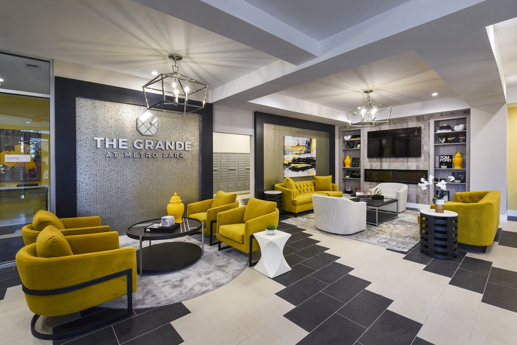a lobby with yellow couches and chairs and a sign that reads the grange