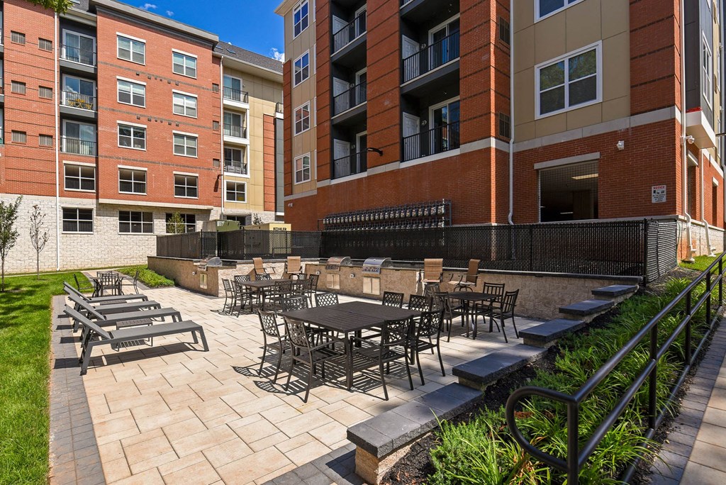 a patio with tables and chairs outside of an apartment building