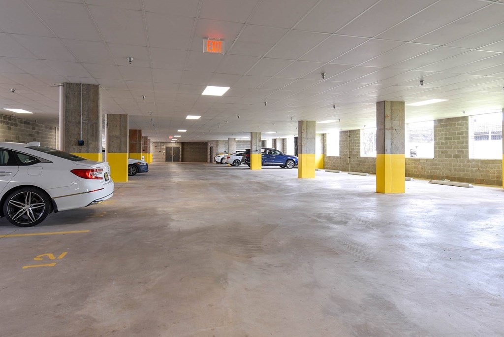 a parking garage with cars in it and an exit sign