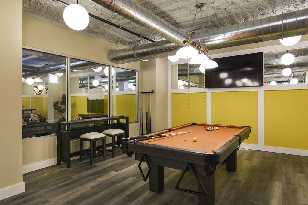 a game room with a pool table and a tv