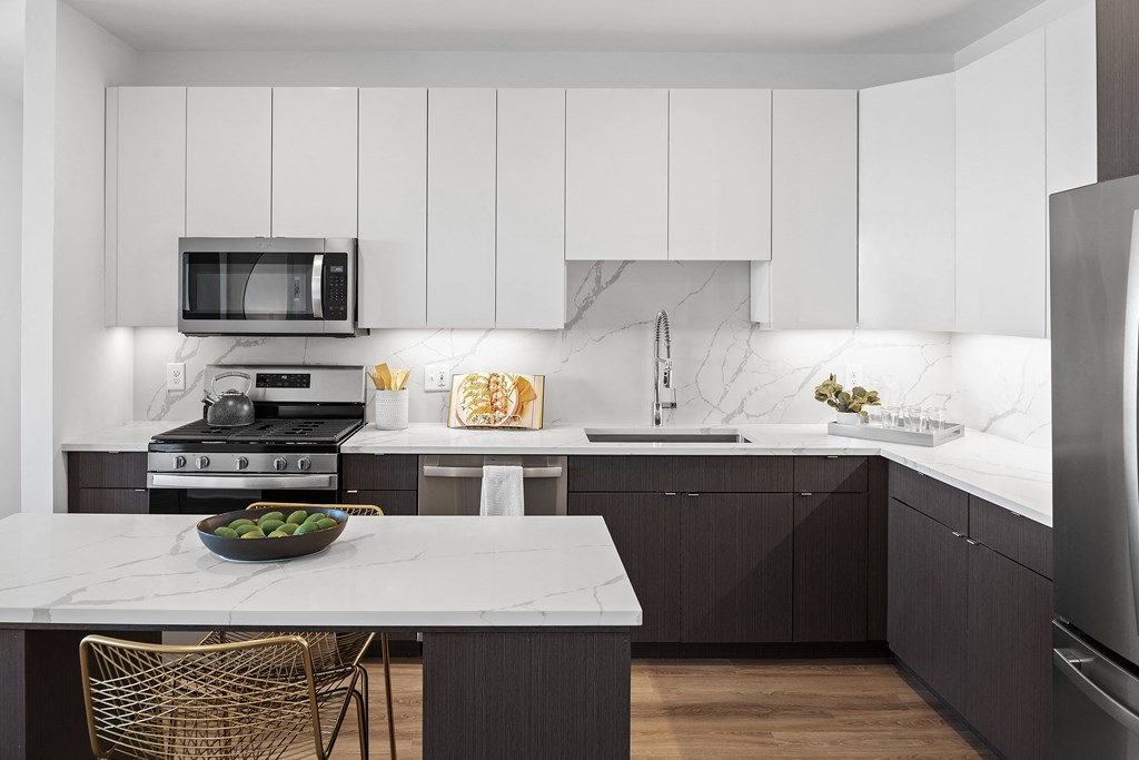 a kitchen with black and white cabinets and a white counter top