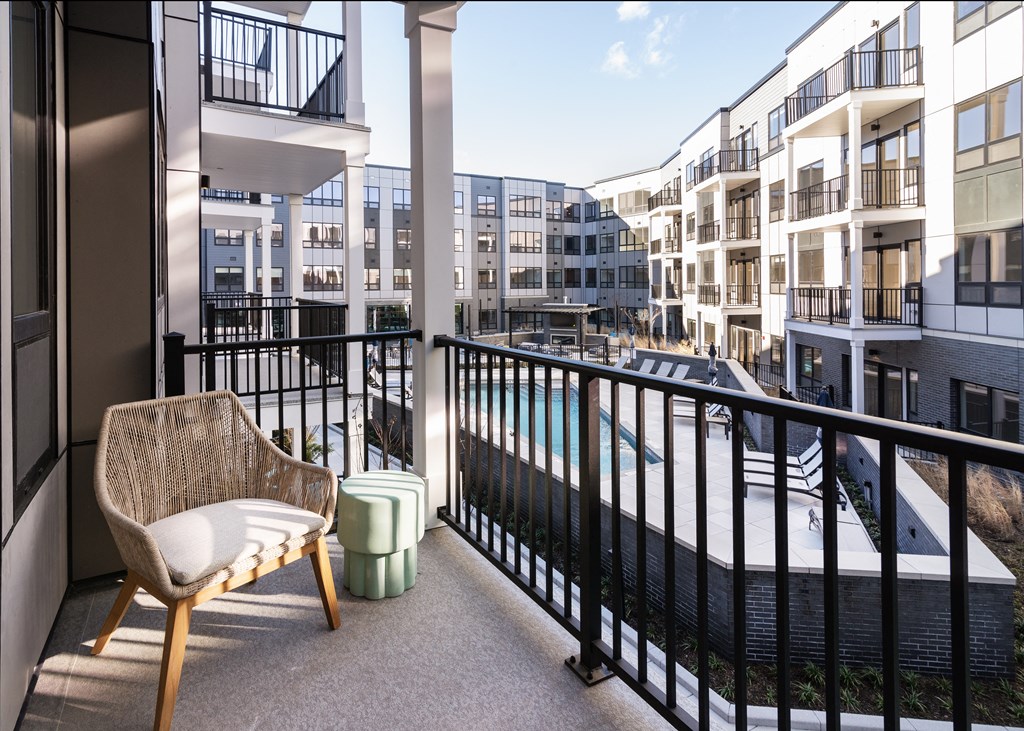 a balcony with a chair and ottoman