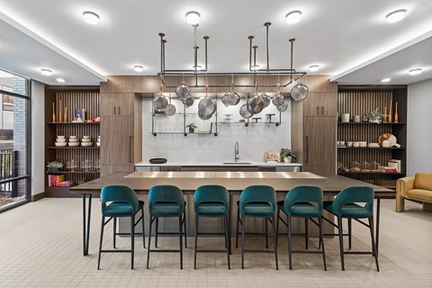a large kitchen with a long table and blue chairs