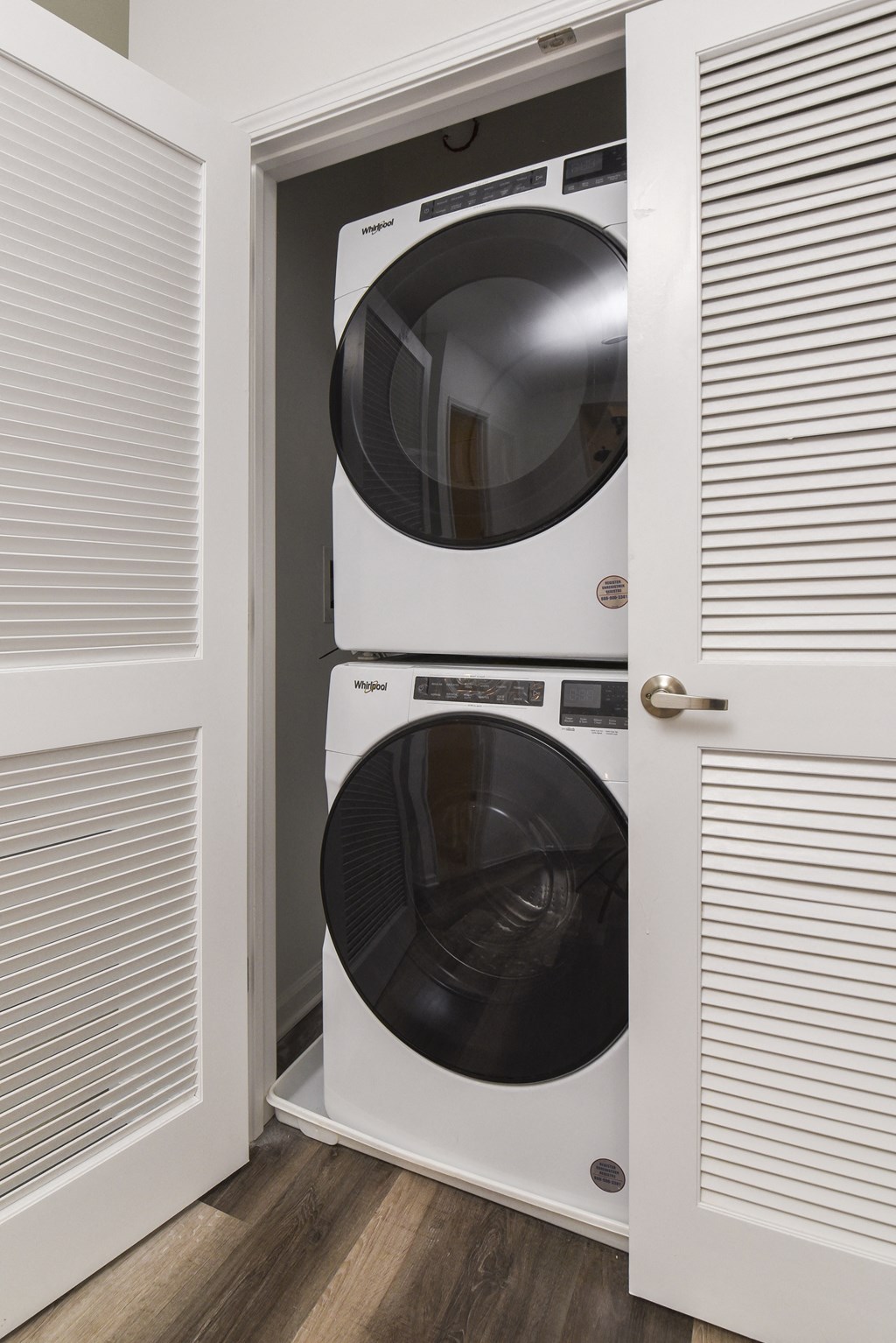 a white front loader washer and dryer in a closet