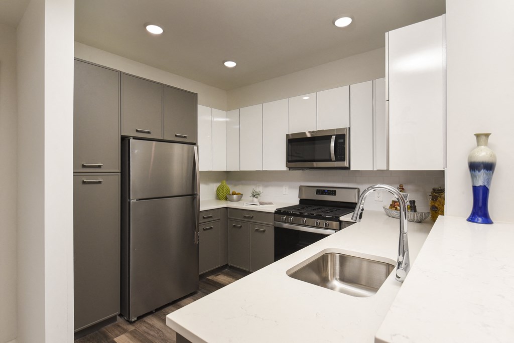 a kitchen with stainless steel appliances and white counter tops