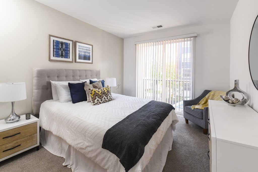 a bedroom with a bed and a couch and a window