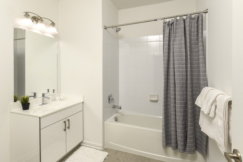 a bathroom with a shower and a sink and a mirror