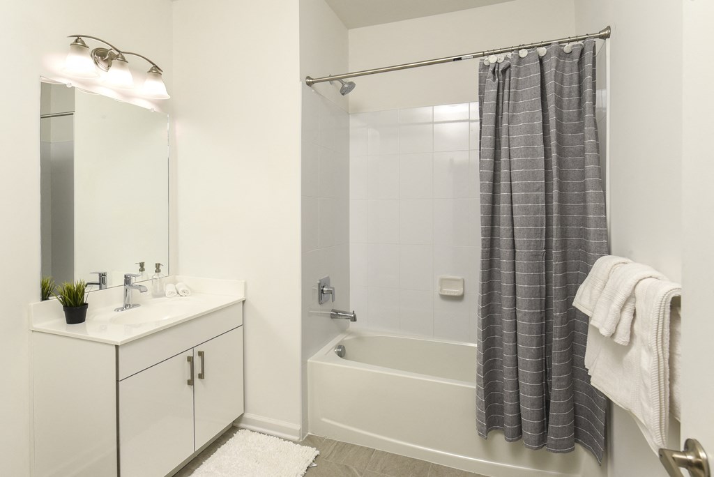 a bathroom with a shower and a sink and a mirror