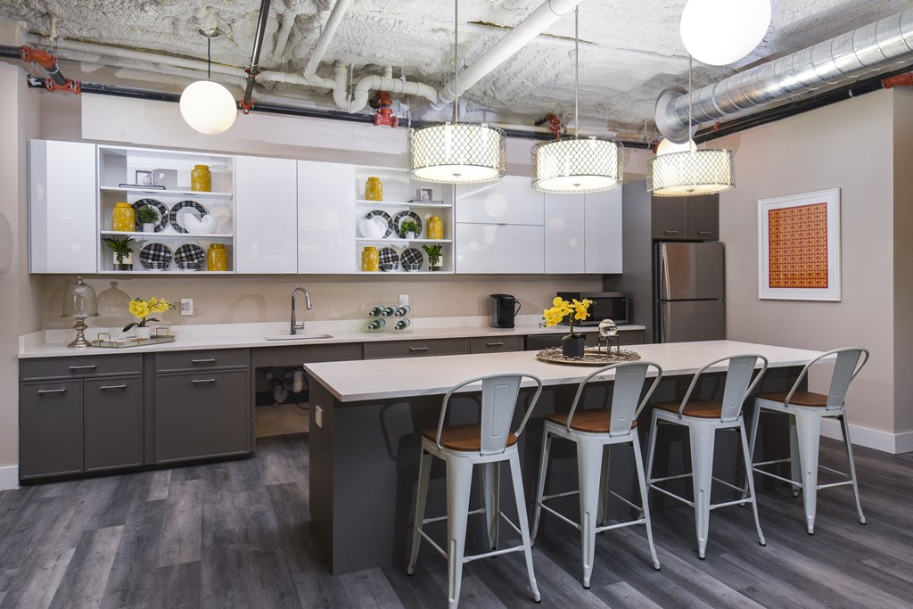 a kitchen with a long island with chairs and a table