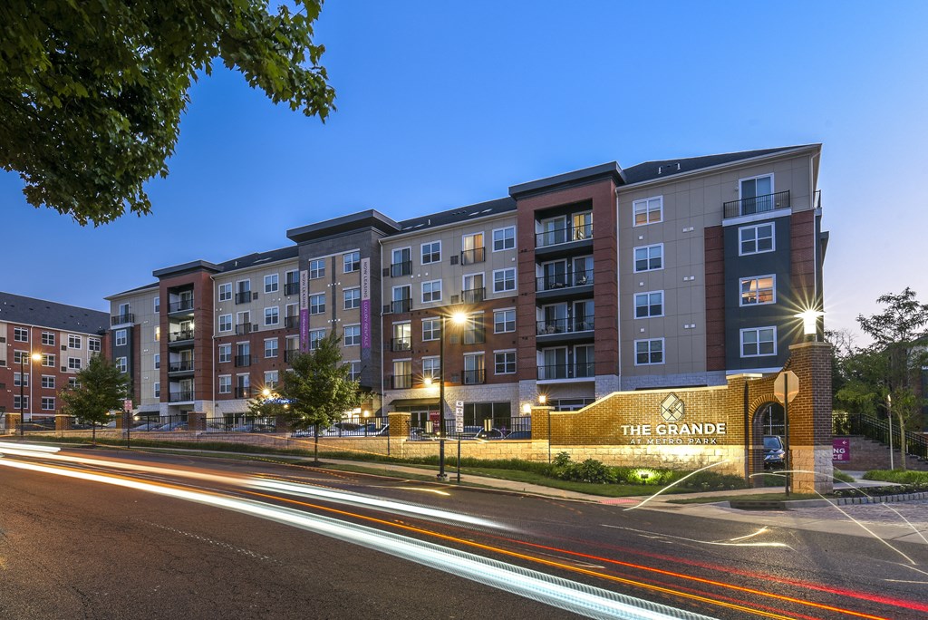 a city street with an apartment building at night