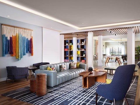 A living room with a blue chair and a grey sofa.