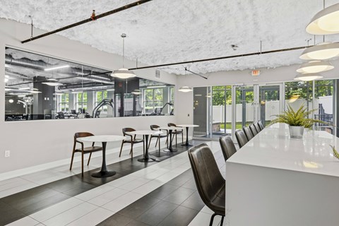 A white and black dining room with a long table and chairs.