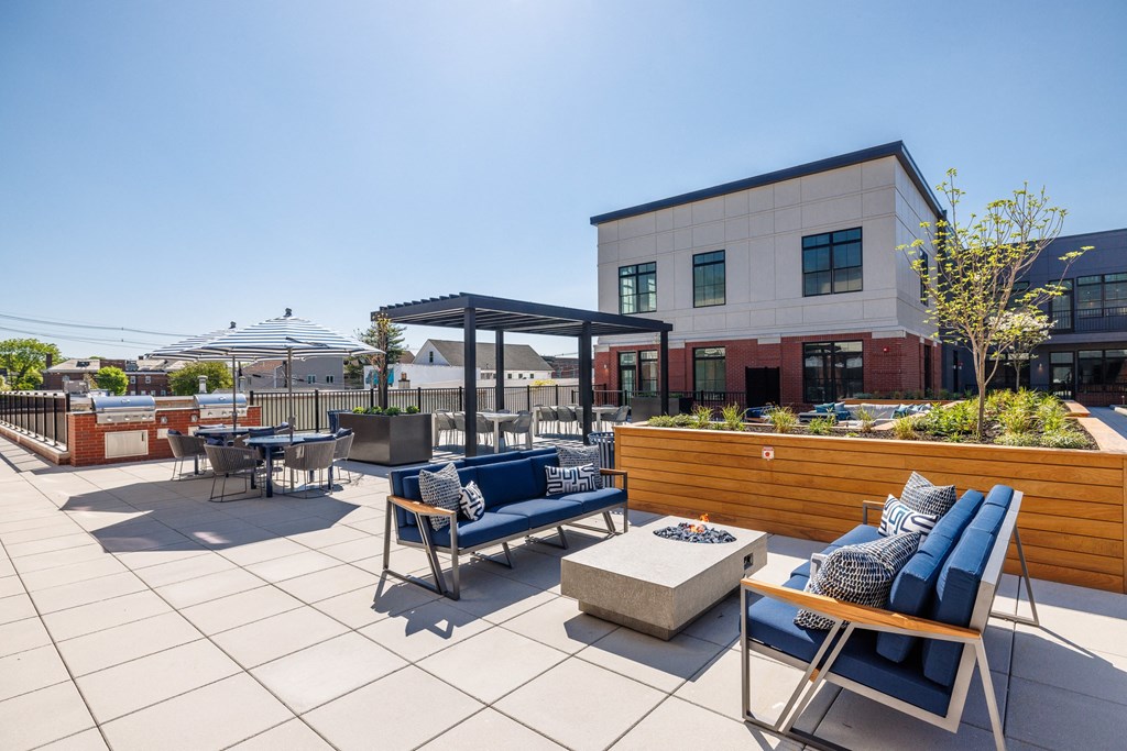 a patio with chairs and tables and a building in the background