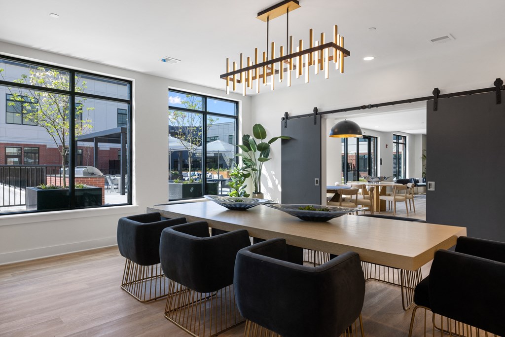 a dining room with a wooden table and chairs and a large window