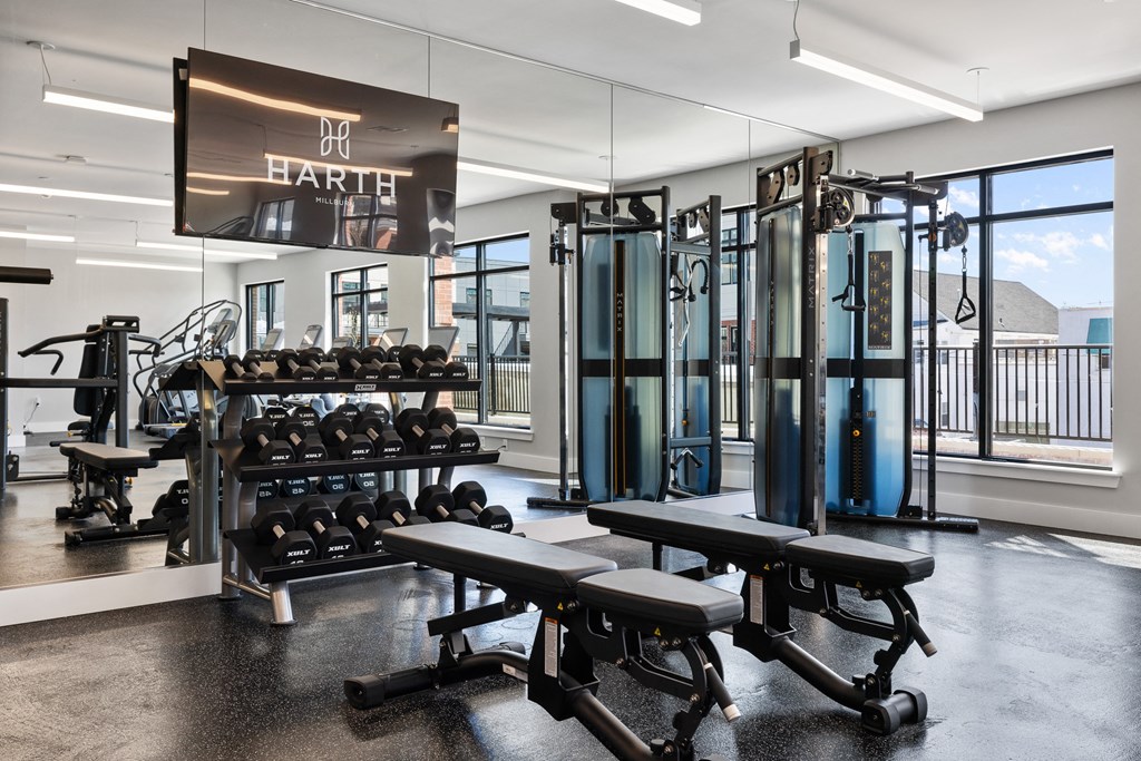a gym with weights and cardio equipment and a sign on the wall
