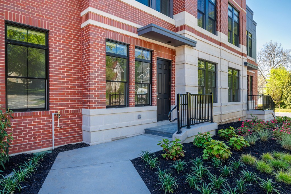 the entrance to a brick building with a concrete sidewalk