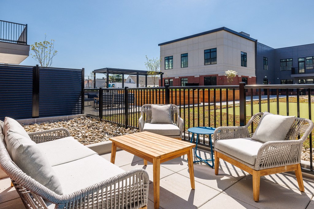 a patio with chairs and tables and a building in the background