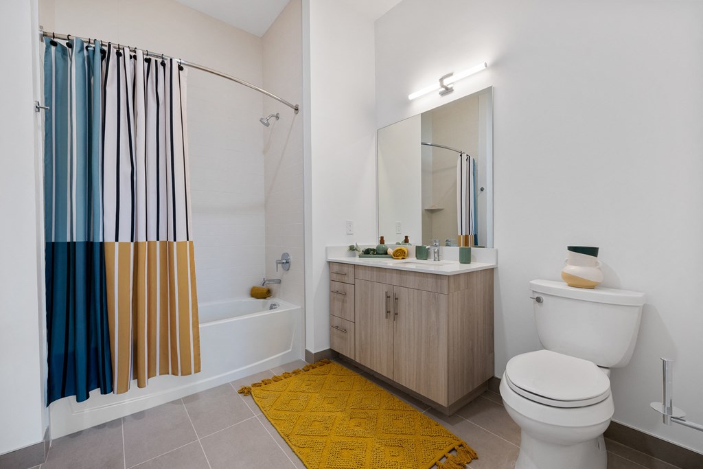 a bathroom with a shower and a toilet and a sink