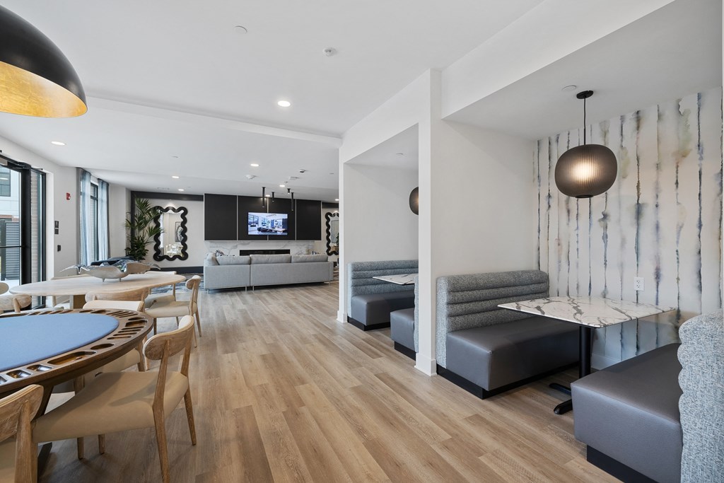 a living room and dining room with white walls and wooden floors