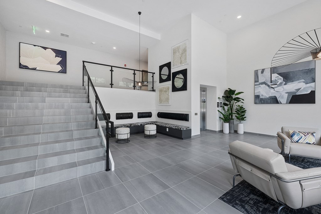 a living room with white walls and a staircase with white furniture