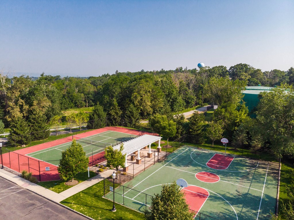 an aerial view of a basketball court and tennis court in a park