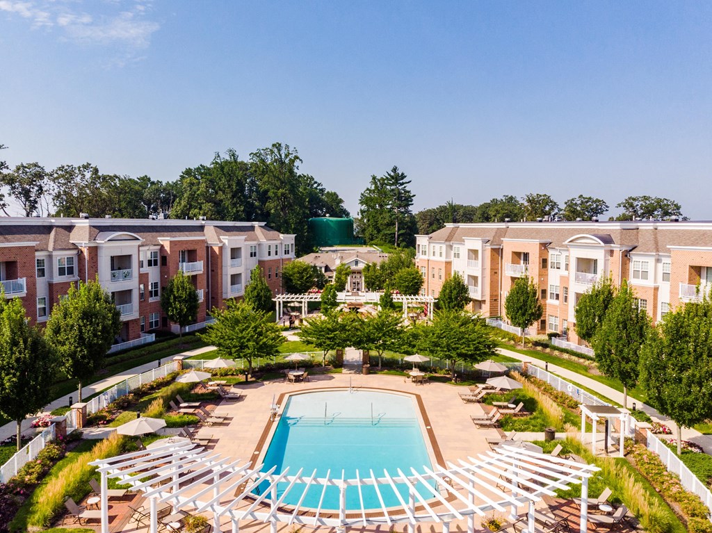 an aerial view of a pool with apartments in the background
