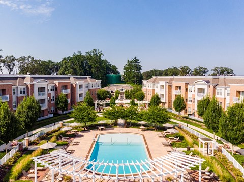 an aerial view of a pool with apartments in the background