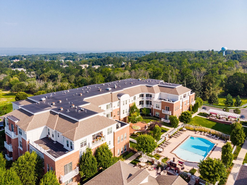 an aerial view of a building with a swimming pool and other buildings