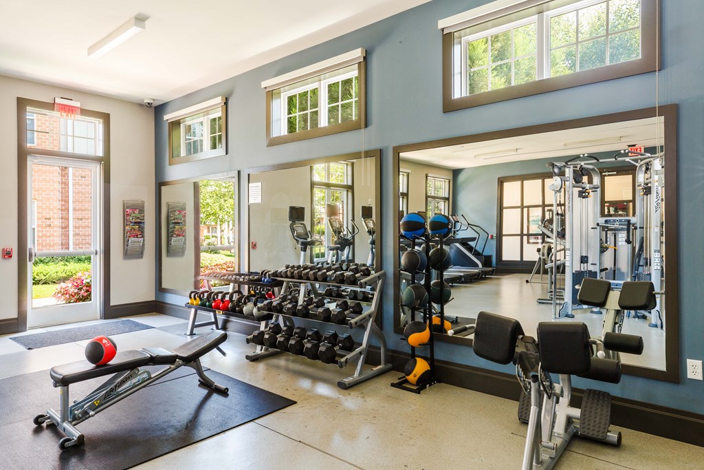 A gym with a variety of equipment including weights and machines.