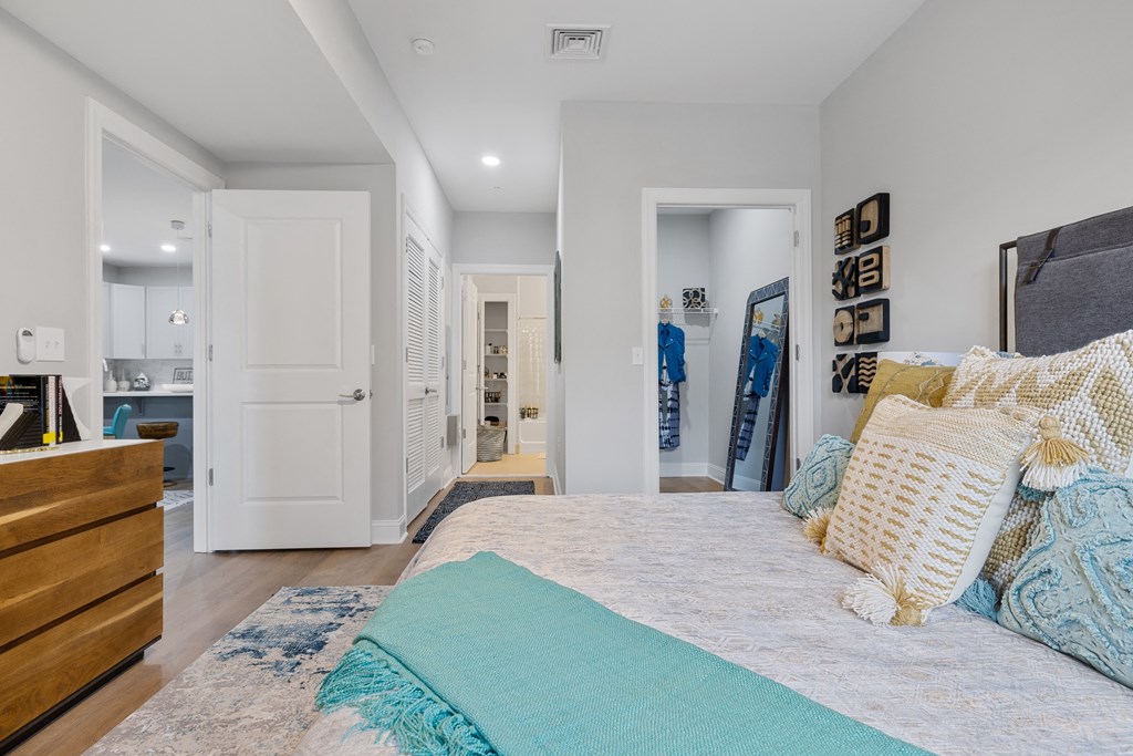 a bedroom with a bed and a dresser and a bathroom